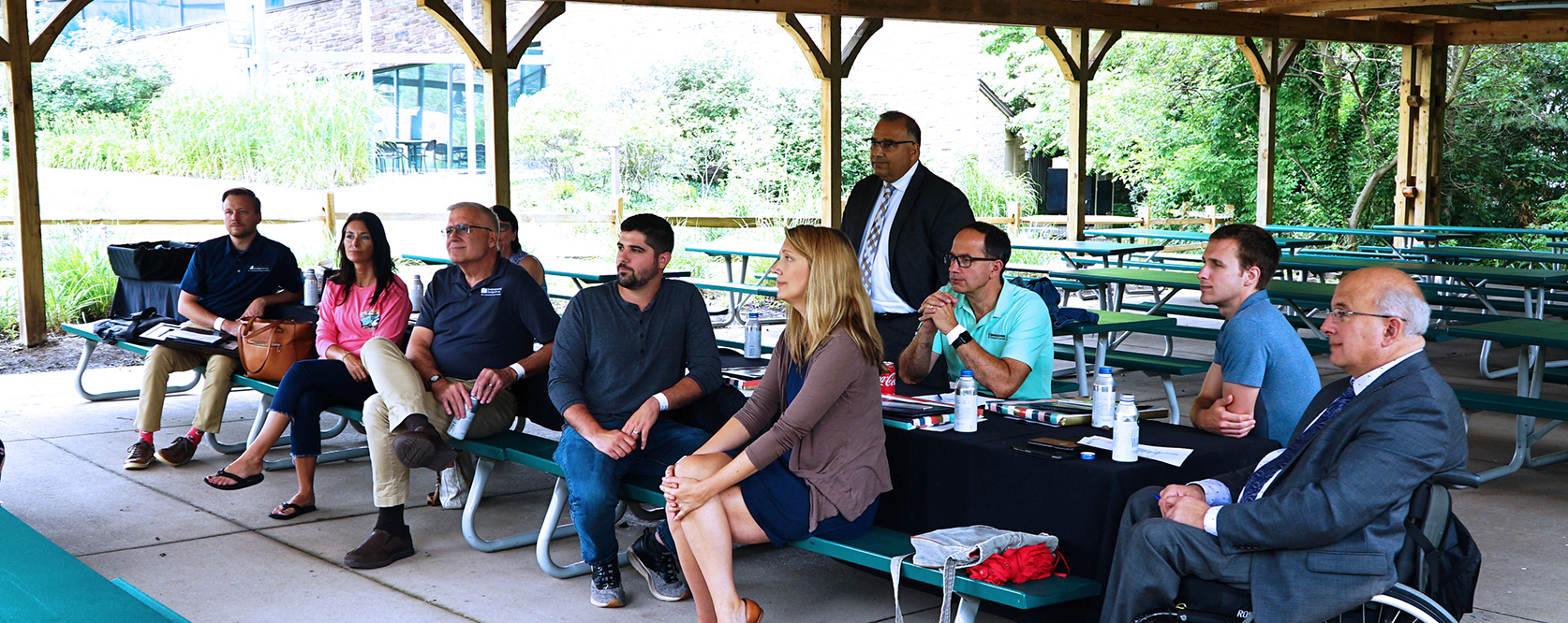 group of people outside at an outdoor table