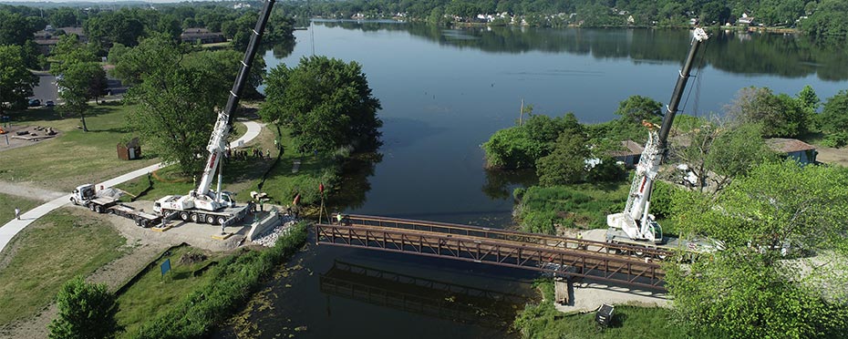 Aerial view of a lake where it turns into a river and a bridge goes over the river.