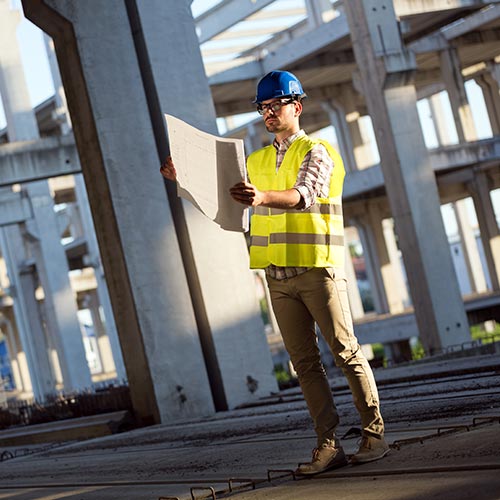 Man examining a blueprint on a construction site