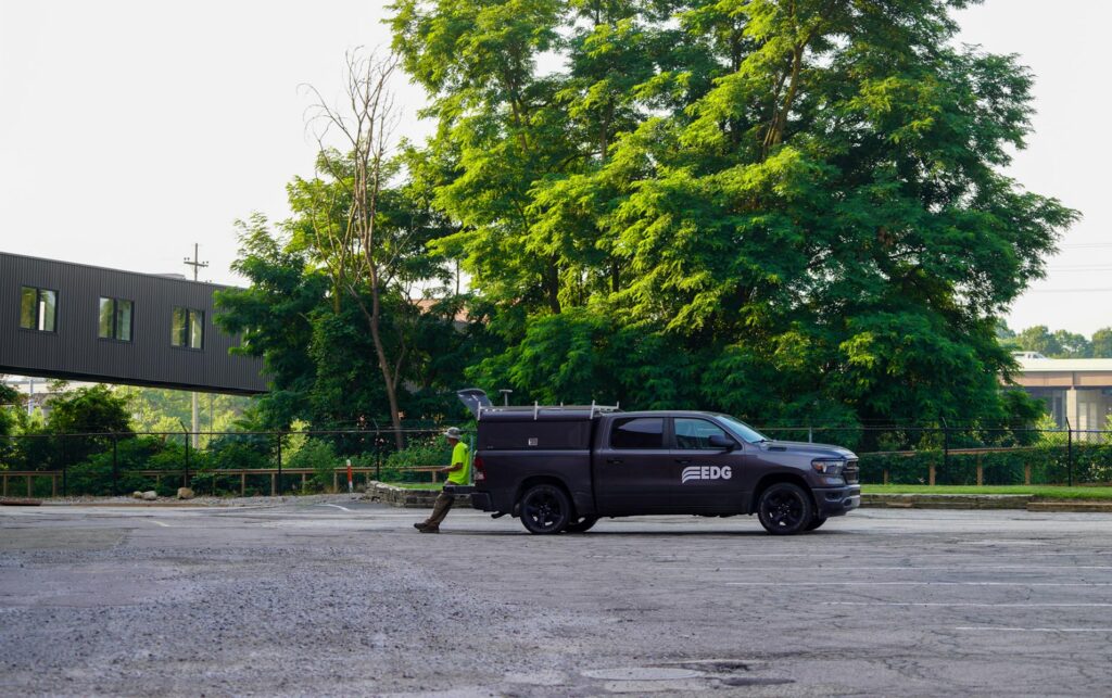 EDG truck in a parking lot with an employee leaning against the back of the truck