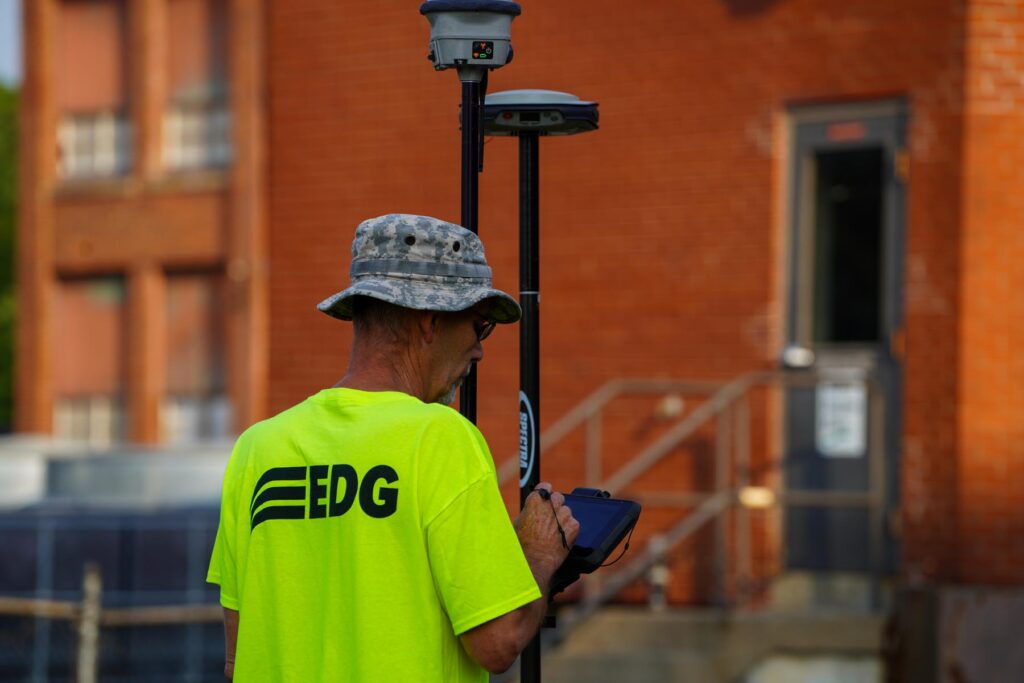Man in a neon shirt, operating a surveying tool