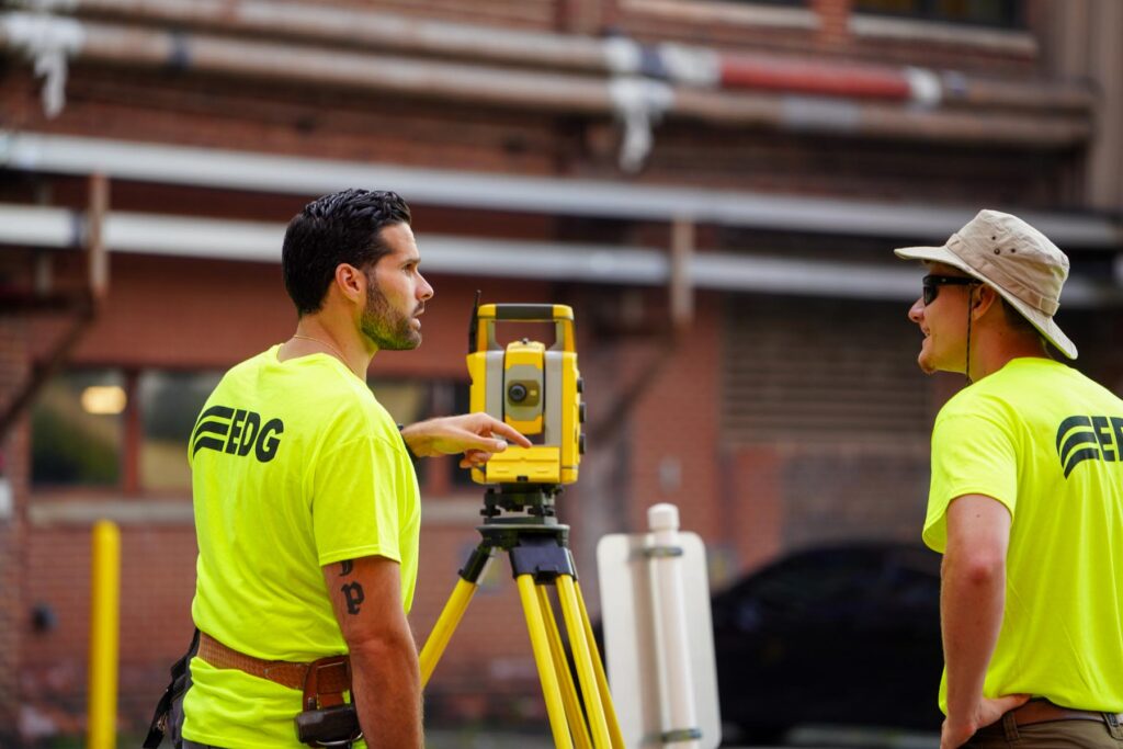 Two men in neon EDG shirts surveying