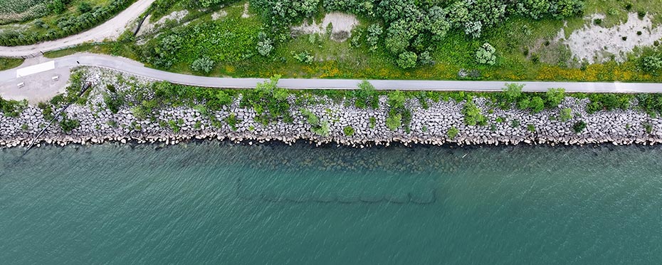 Aerial view of a lake with rocks retaining the shore